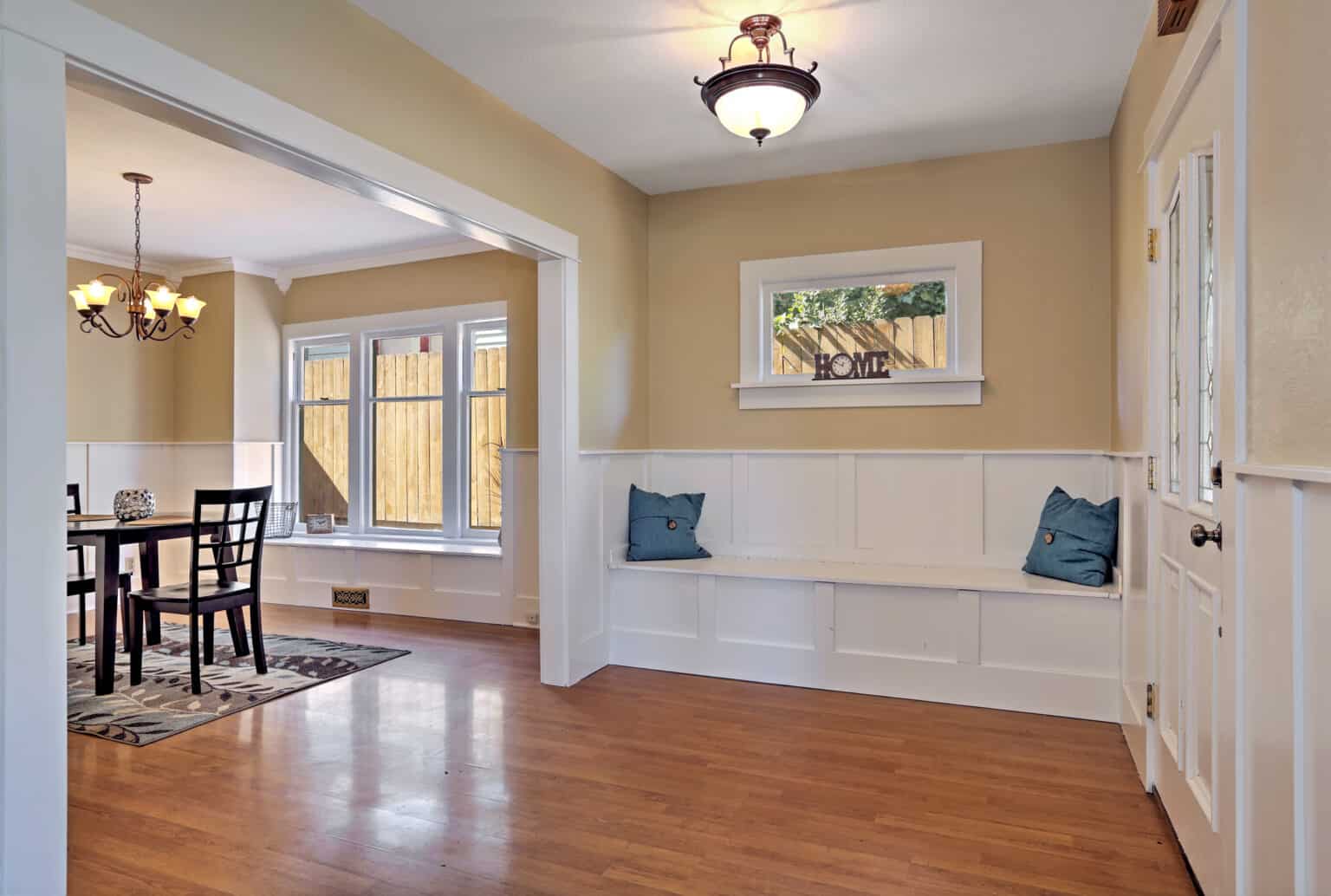 entrance hall with wood paneled walls and comfortable seat