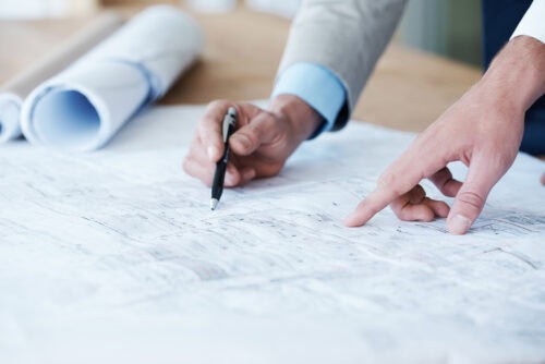 Hands pointing at architectural blueprint