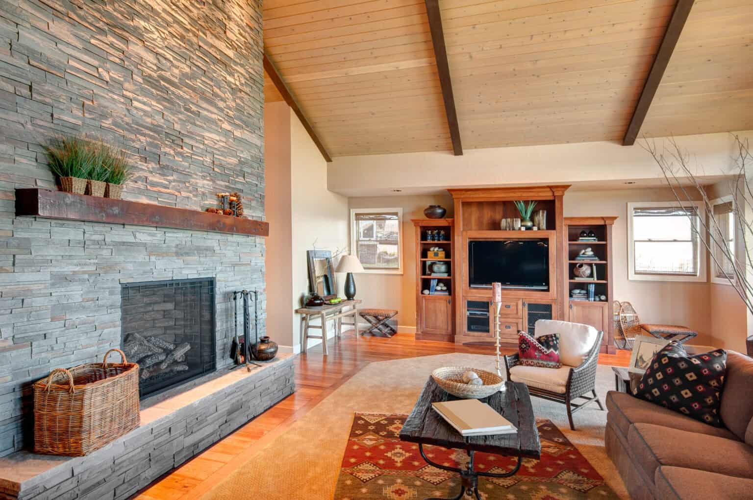 living room in luxury home with fireplace and tv