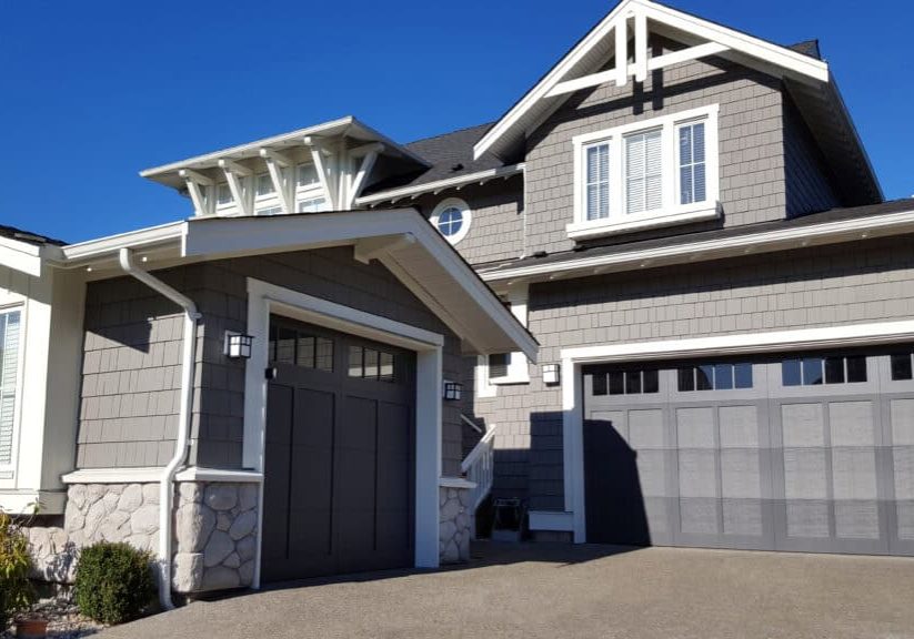 shingle style home with double and single car garages