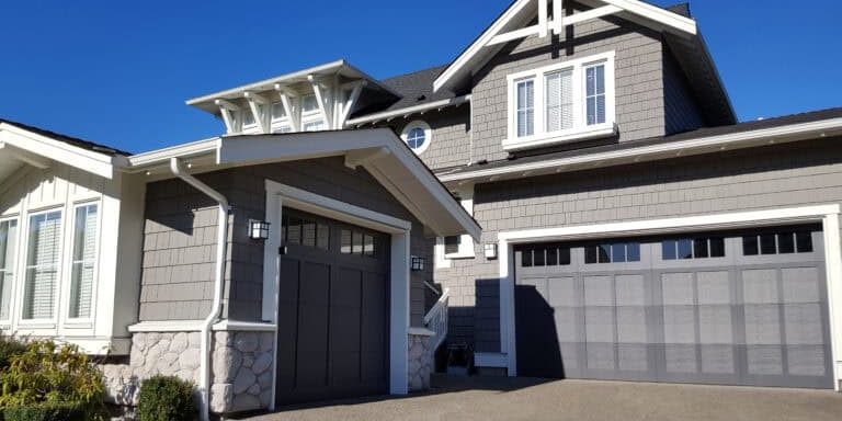 shingle style home with double and single car garages